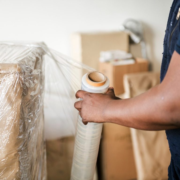 Mitarbeiter verpackt professionell die Möbel beim Umzug